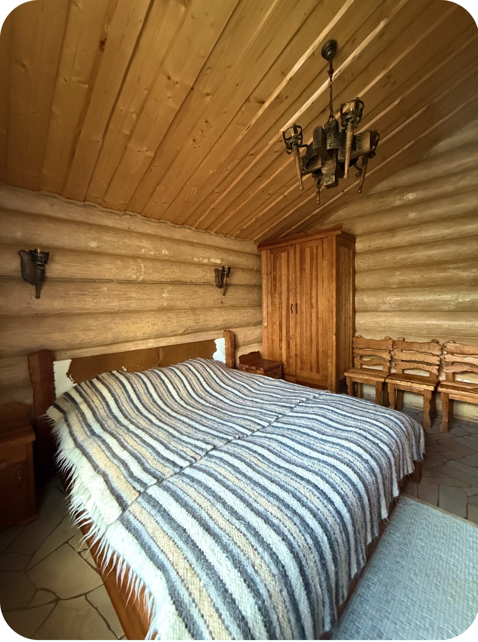Спальня 1, фото 1: кімната з дерев'яними стінами та великим ліжком, підвісна люстра