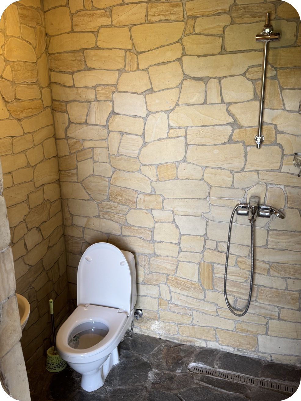 Вбиральня на території з кам'яними стінами і душовою кабіною